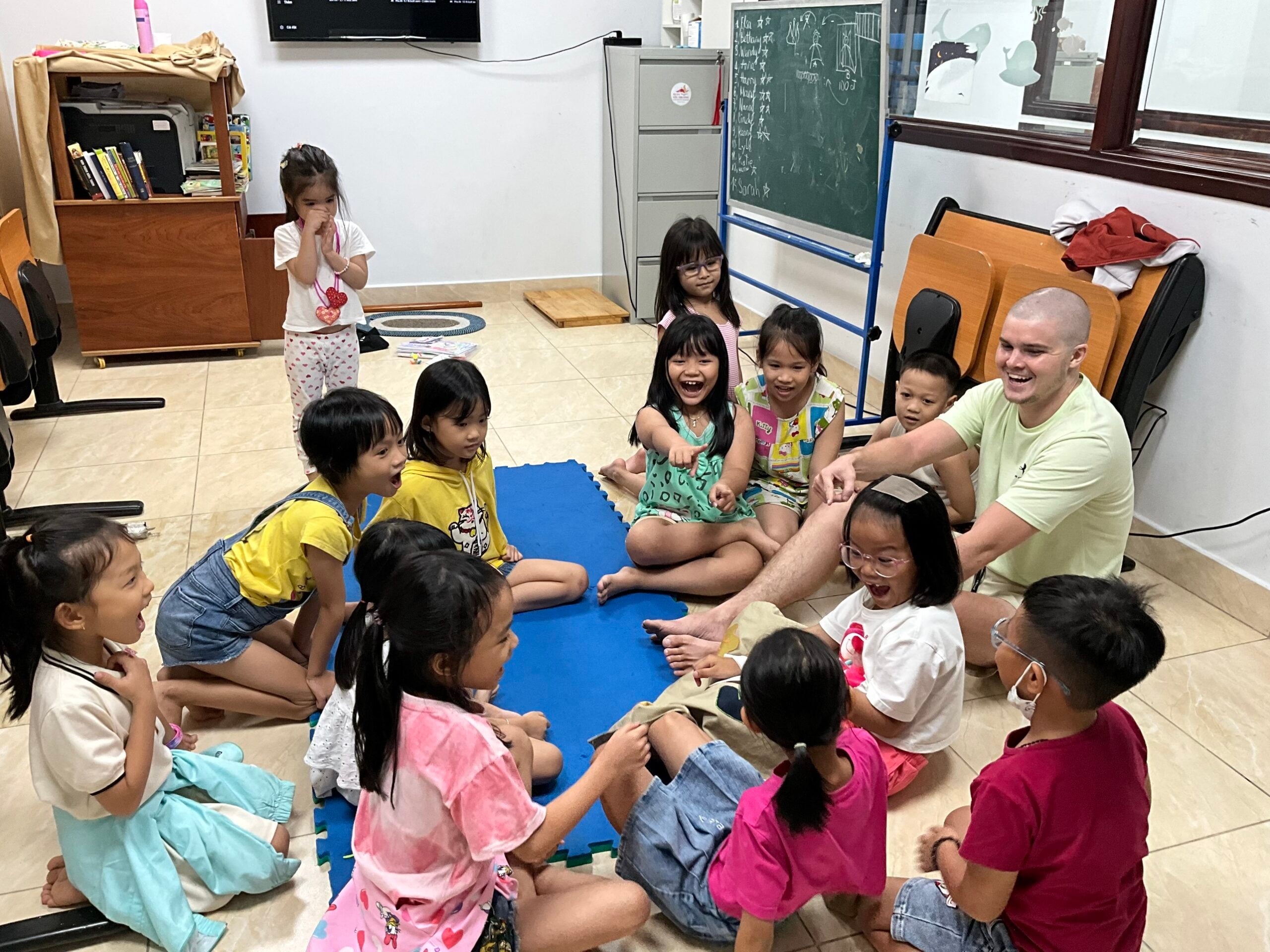 A volunteer playing a game with children at an English club